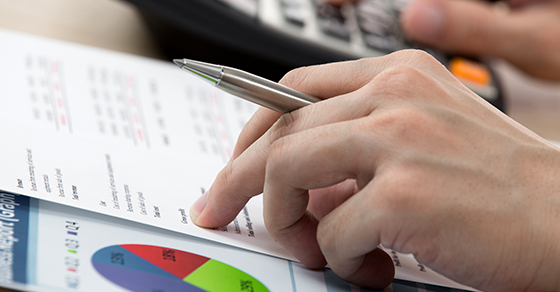 Person reviewing spreadsheets and charts