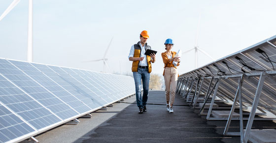 Two workers inspecting solar panels