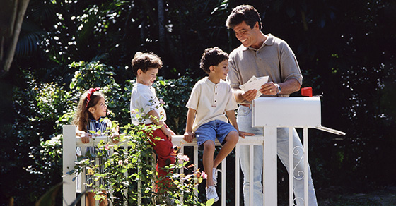 Father and three children going through the mail at the mailbox