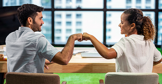 Two employees fist bumping