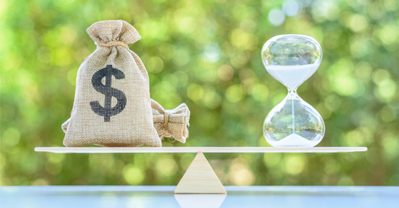 A bag of money and hourglass balancing