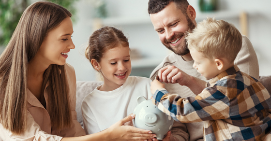 Family putting money in piggy bank