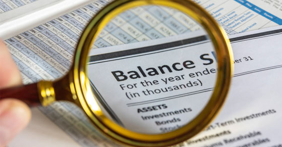 Magnifying glass over balance sheet