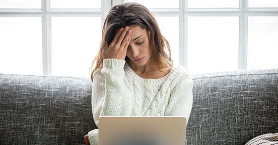 a stressed woman looking at a laptop