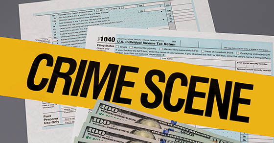 1040 individual income tax return with crime scene tape. Identity theft, tax fraud and cybercrime concept