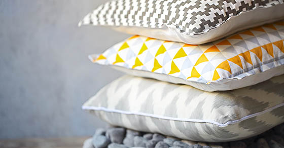 Yellow and grey pillows on the wall background