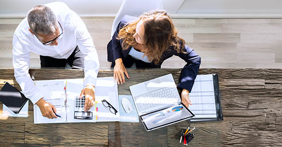 Manager,And,Senior,Accountant,Using,Laptop,In,Office